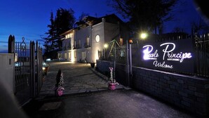 Ein begrenzter Eingang zu einem Anwesen namens "Ristorante Principe" mit einer einladenden Schautafel und einem gepflasterten Weg.