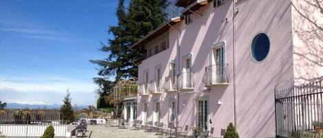 A pink building with balconies and a stone-paved courtyard.