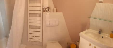Un baño con ducha, inodoro y lavabo.