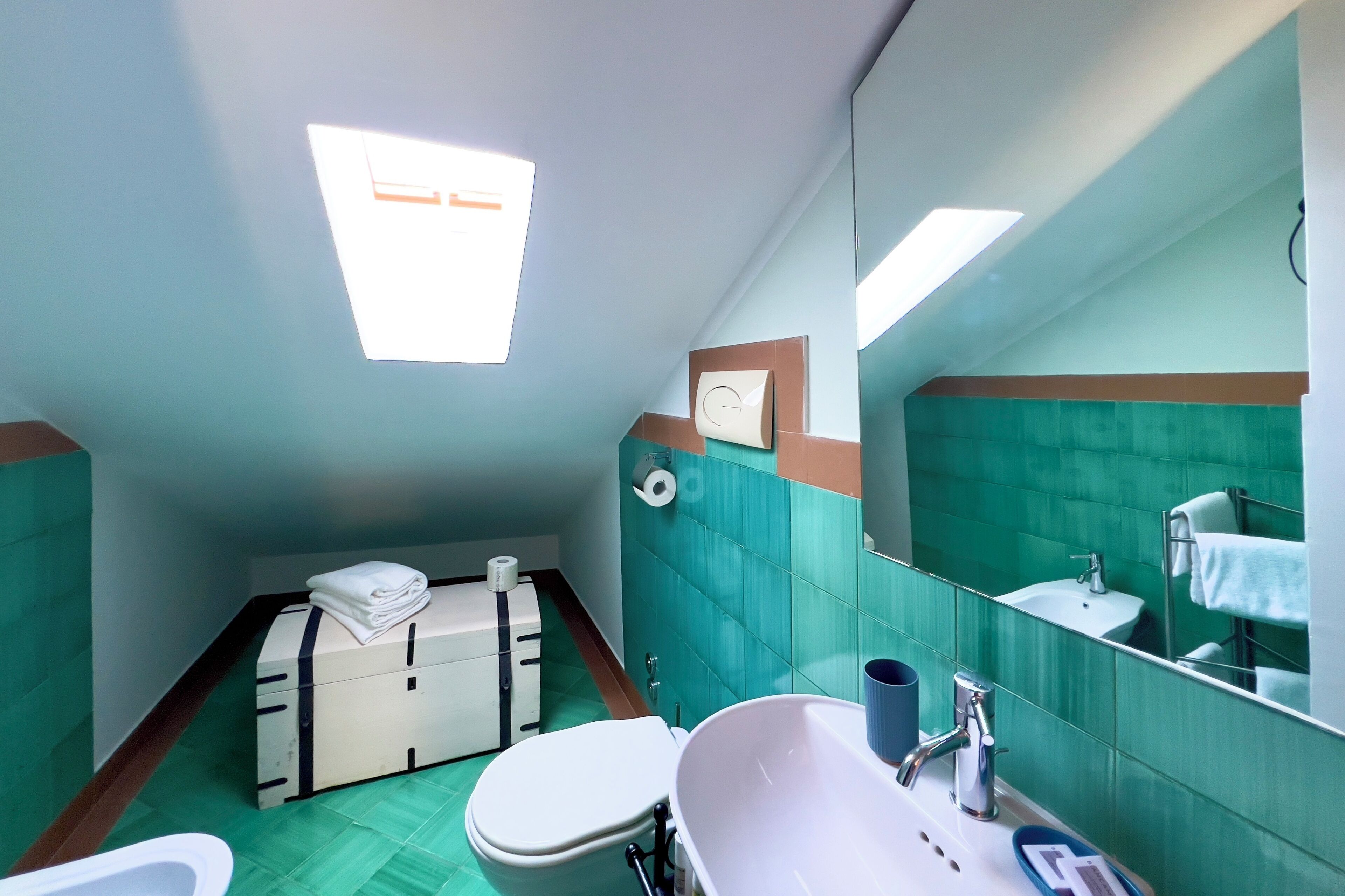 A bathroom with a toilet, sink, and mirror.