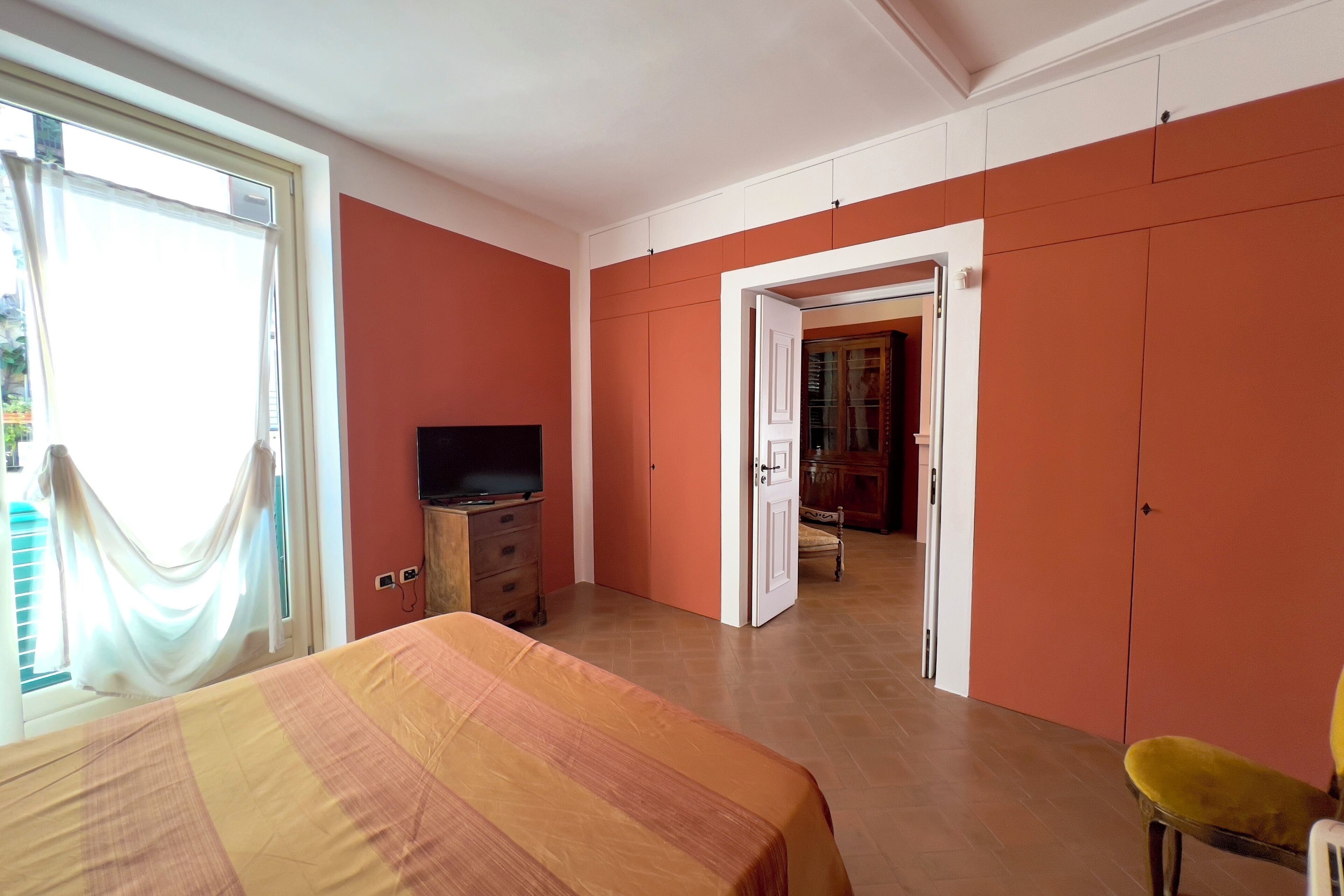 A bedroom with a bed, a television, and a wardrobe.