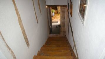 A narrow staircase with wooden steps leading to a doorway.