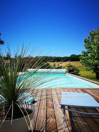 Una piscina al aire libre de temporada, sombrillas