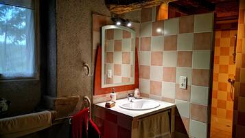 Un baño con lavamanos, espejo y ducha.