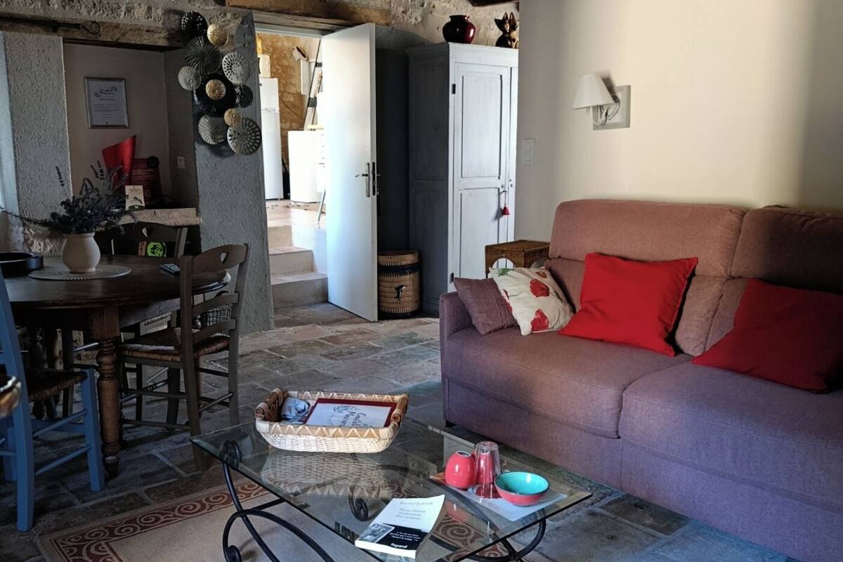 A cozy living room with a wooden ceiling, a sofa, a dining table, and a coffee table.