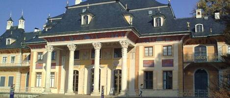 A large, historic building with a symmetrical facade, prominent columns, and a central entrance.