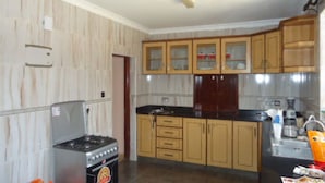Cozinha com armários de madeira, fogão a gás e micro-ondas.