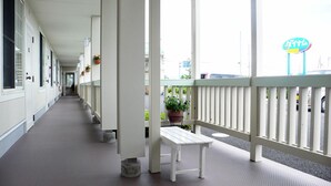A corridor with white walls, doors, and a bench on a balcony. - Family Lodge Hatagoya Hikone (Aisho)