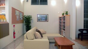 Una sala de estar acogedora con un sofá color beige, una mesa de centro de madera y una estantería.