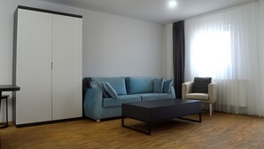 A modern living room with a sofa, a coffee table, a chair, and a wardrobe.