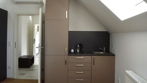 A compact kitchen with a skylight, a built-in stove, and a small sink.