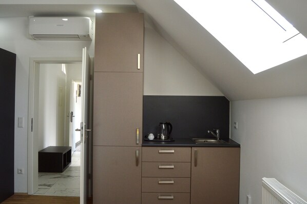 A compact kitchen with a skylight, a built-in stove, and a small sink.
