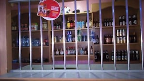 A bar area with shelves stocked with various bottles and cans. - New Journa Complex Hotel (Naro Moru)