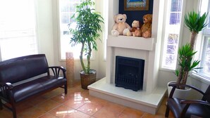 A living room with a fireplace, a sofa, a coffee table, and a potted plant. - Family Lodge Hatagoya Iga (Iga)