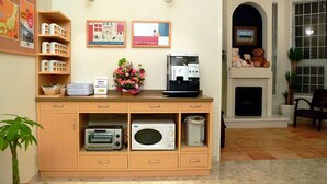 A kitchen area with a coffee machine, microwave, toaster, and a small cabinet with kitchen utensils. - Family Lodge Hatagoya Iga (Iga)