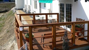 A wooden deck with outdoor furniture, a green awning, and potted plants. - Family Lodge Hatagoya Toki (Toki)
