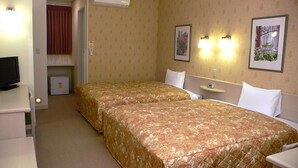 A hotel room with two beds, a television, a small refrigerator, and two wall-mounted light fixtures. - Family Lodge Hatagoya Toki (Toki)
