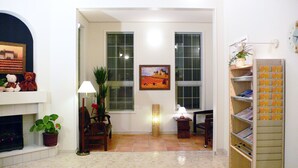A living room with a fireplace, a painting, a lamp, a chair, and a bookshelf. - Family Lodge Hatagoya Nirasaki (Nirasaki)
