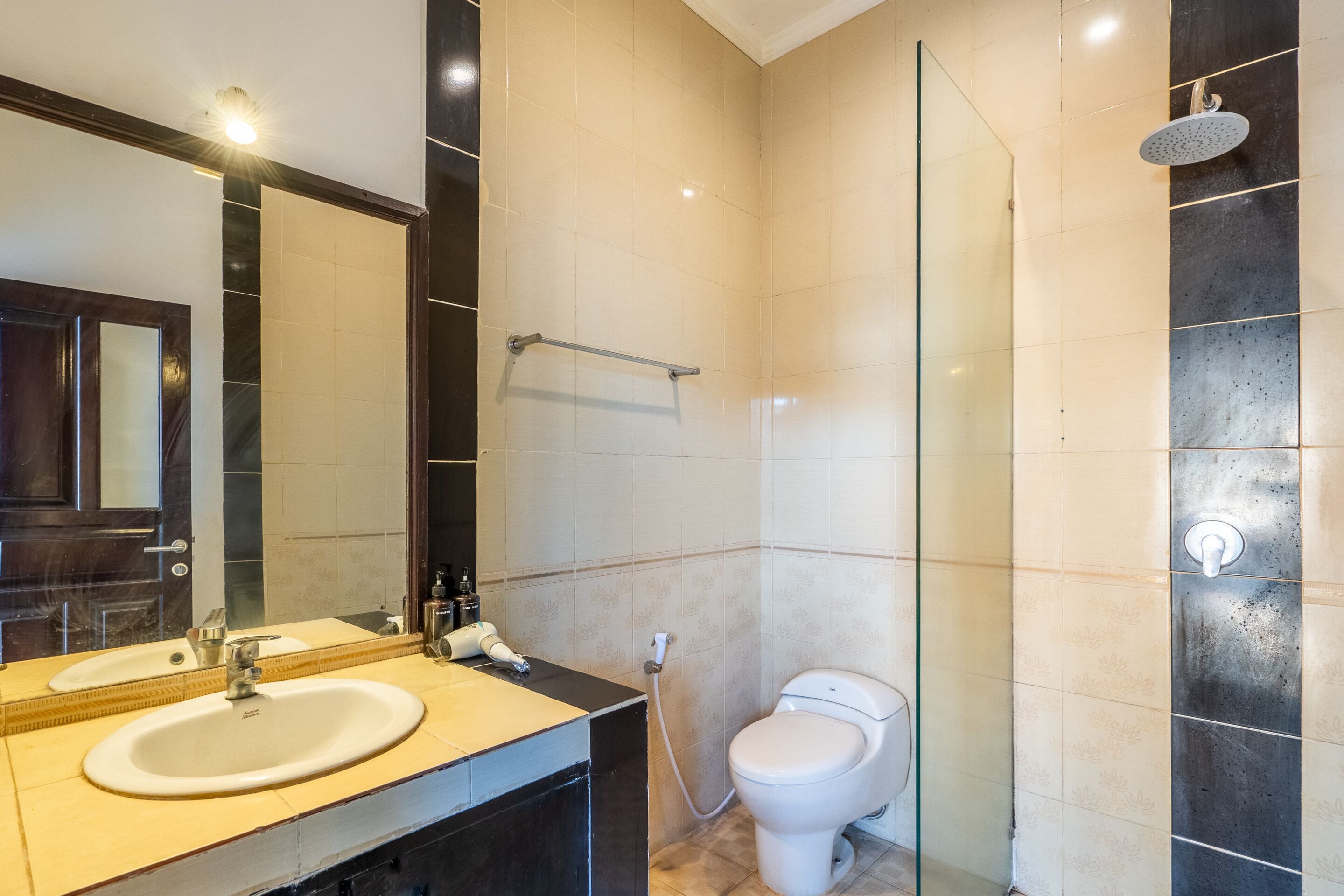 A modern bathroom with a sink, mirror, and a glass-enclosed shower.