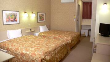A hotel room with two beds, a desk, a chair, a television, and a refrigerator.