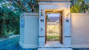 Une entrée fermée par un portail, sur laquelle on peut lire l’inscription « Villa Melati ».