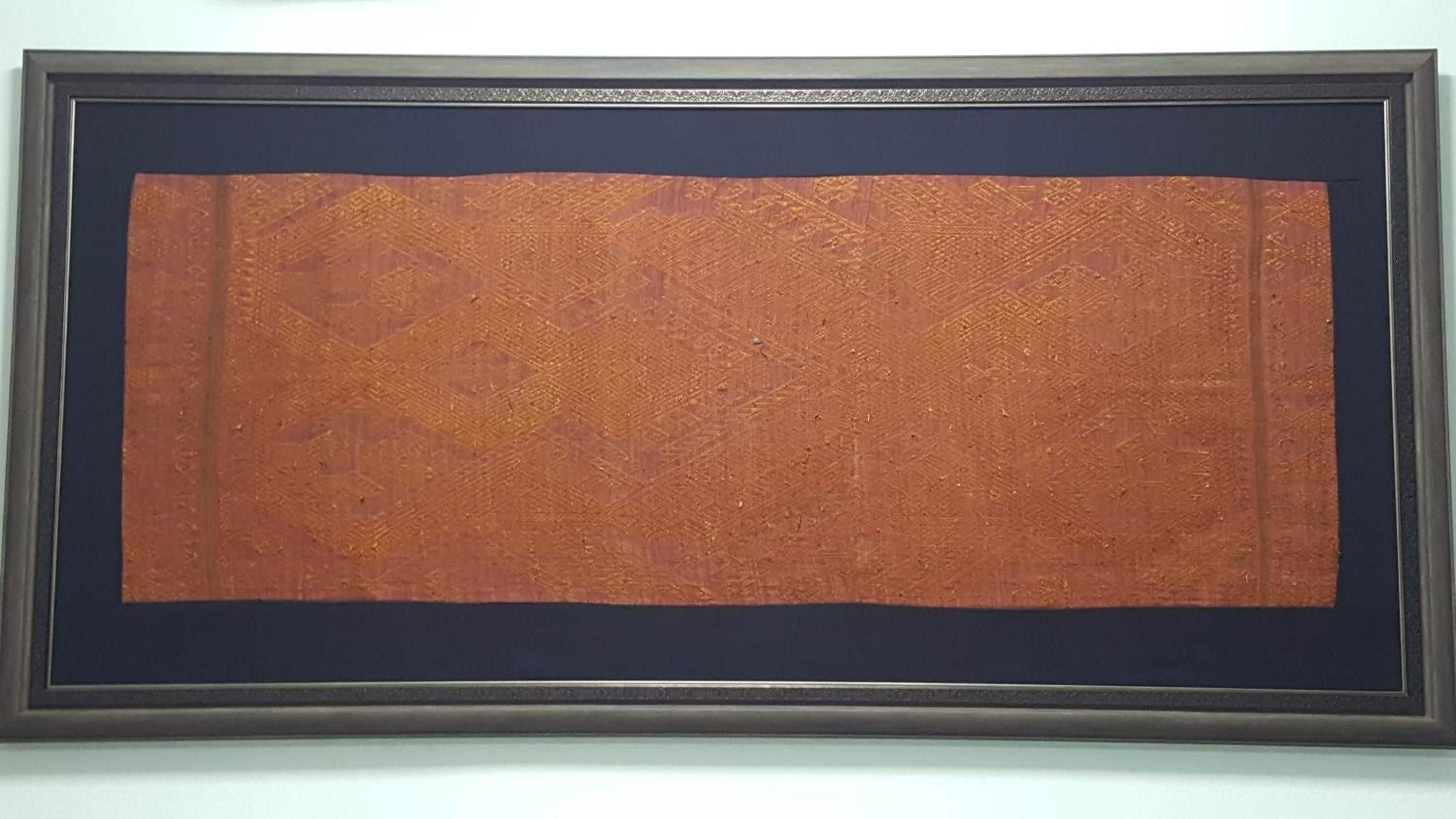 Ein gerahmtes Kunstwerk mit einer strukturierten Oberfläche und dunklem Rand.