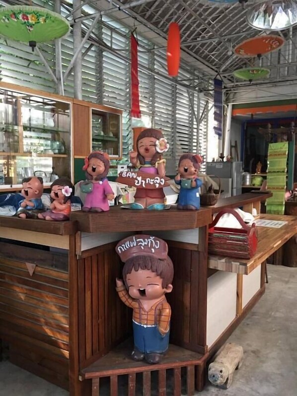 A display of figurines on a counter with a wooden base, surrounded by a metal structure with hanging decorations.