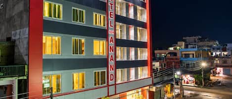 A multi-story hotel with a prominent vertical sign indicating its name.