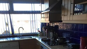 A kitchen with a sink, stove, and cabinets. - Sturry House (Canterbury)