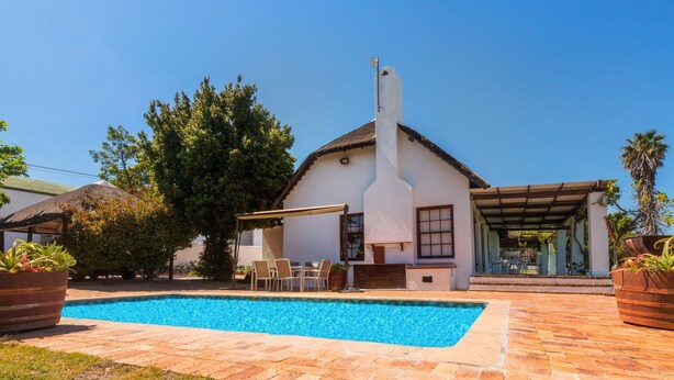 A house with a swimming pool, outdoor seating, and a covered patio area. - Saxenburg Wine Farm (Cape Town)