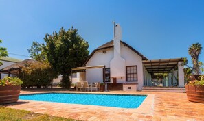 A house with a swimming pool, outdoor seating, and a covered patio area. - Saxenburg Wine Farm (Cape Town)