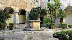 A courtyard with a fountain, arches, and potted plants. - Villa Garibaldi. Beautiful mountain town in wine area ½ hour from Rome and beach (Cori)