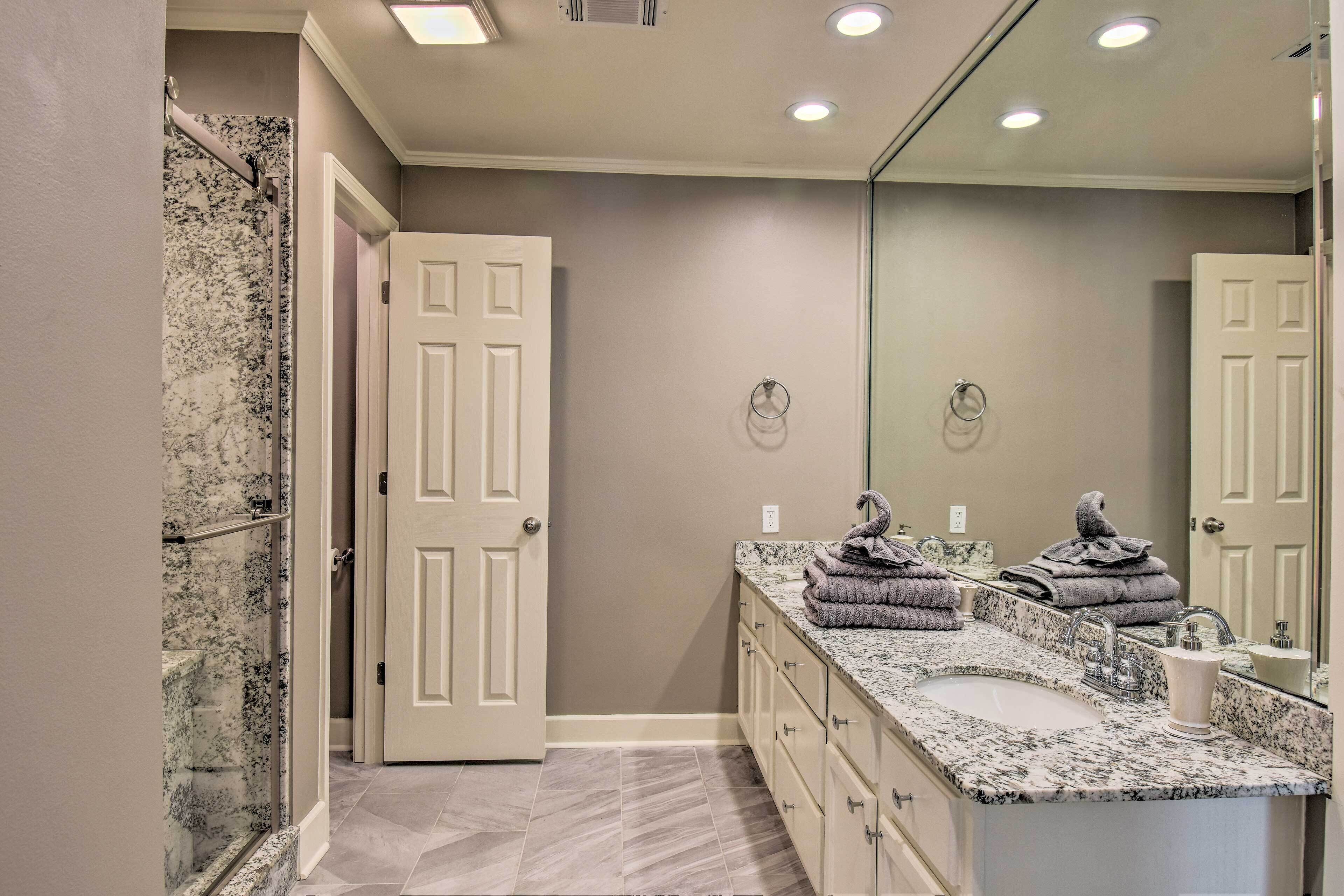 Une salle de bain avec un double lavabo, un grand miroir et un espace douche.