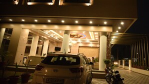 Entrada de hotel com uma placa que diz "SK GRAND HOTEL RESTAURANT BANQUET".
