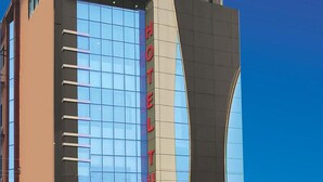 A modern hotel building with a prominent 'HOTEL' sign on the facade.