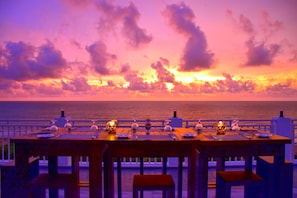A table set for dining with a view of the ocean and sunset. - Ruvisha Beach Hotel (Negombo)