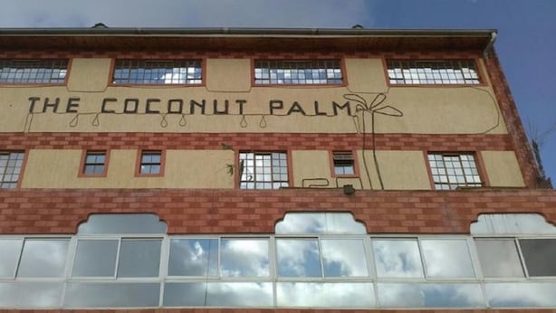 Un edificio con el letrero "The Coconut Palm" en la fachada.