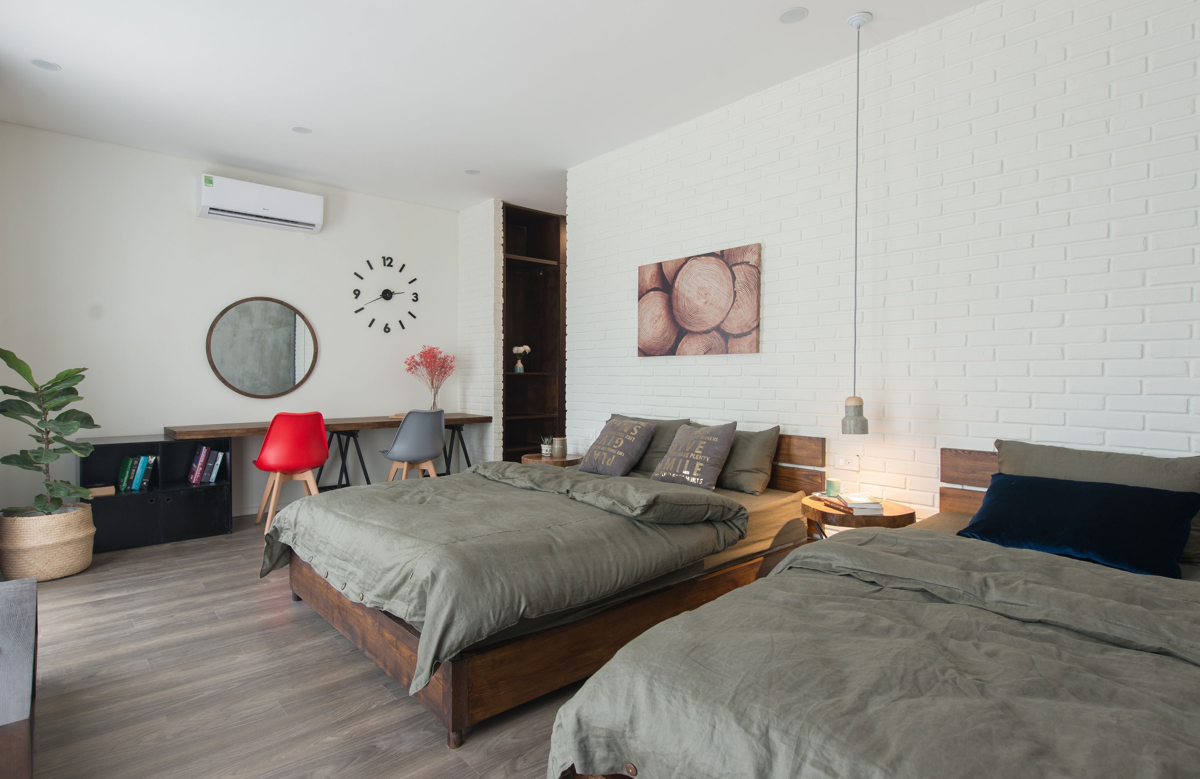 A modern bedroom with a large bed, a desk, and a bookshelf.