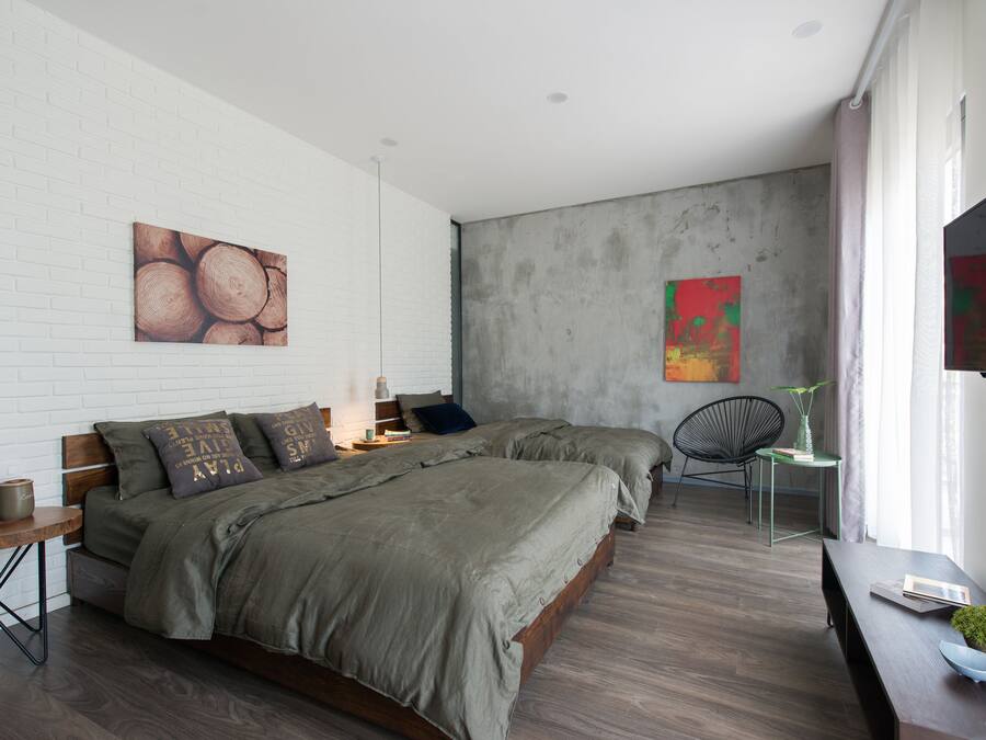 A modern bedroom with a large bed, a small table, and a chair.