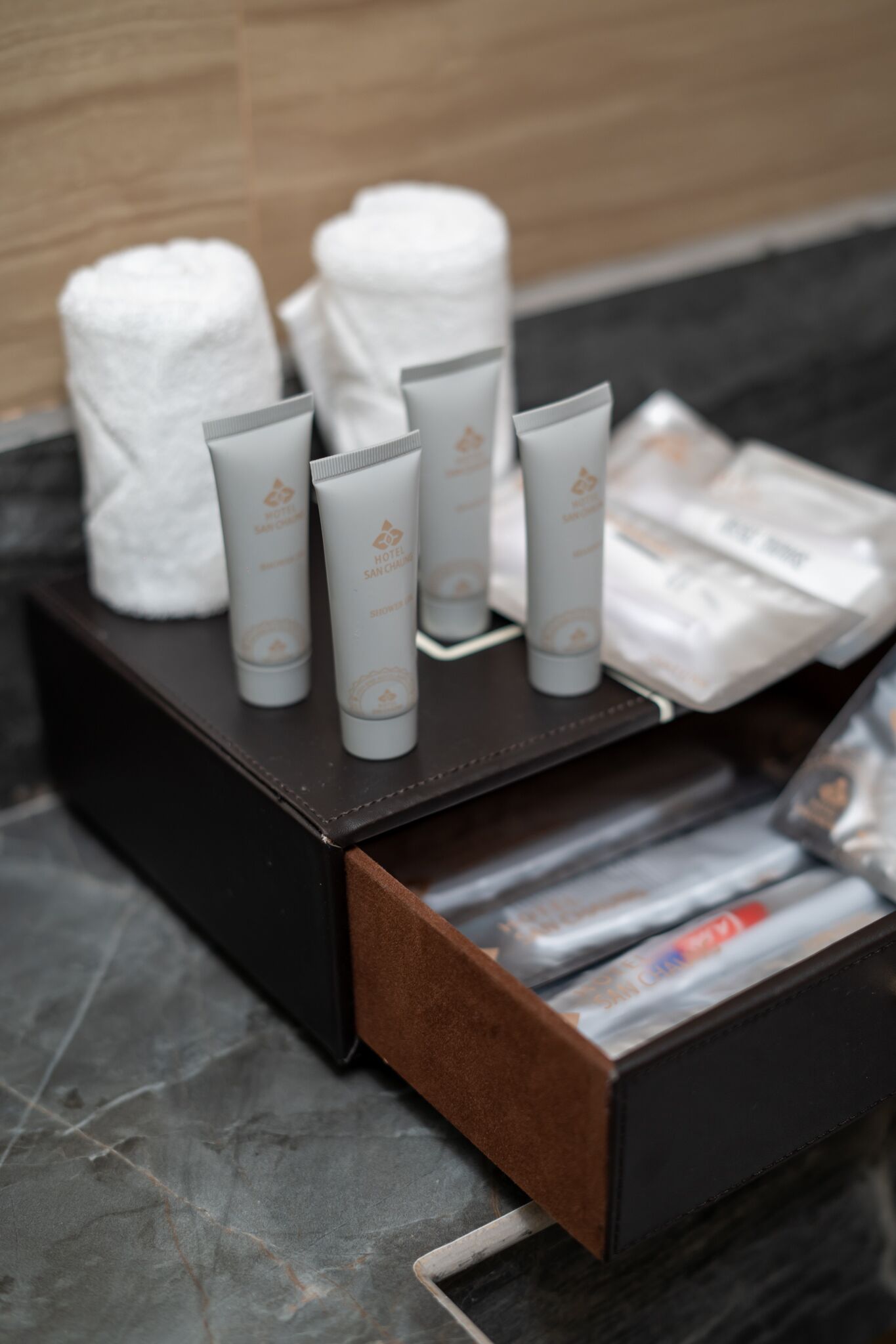 A hotel room with a bathroom counter displaying toiletries and towels.
