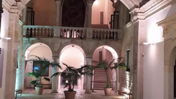 A spacious interior with arched ceilings and a central column, featuring a stone floor and potted plants. - Casa Belvedere Suite (Barletta)
