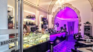 A restaurant interior with a glass display case, a bar area, and a seating section. - Casa Belvedere Suite (Barletta)