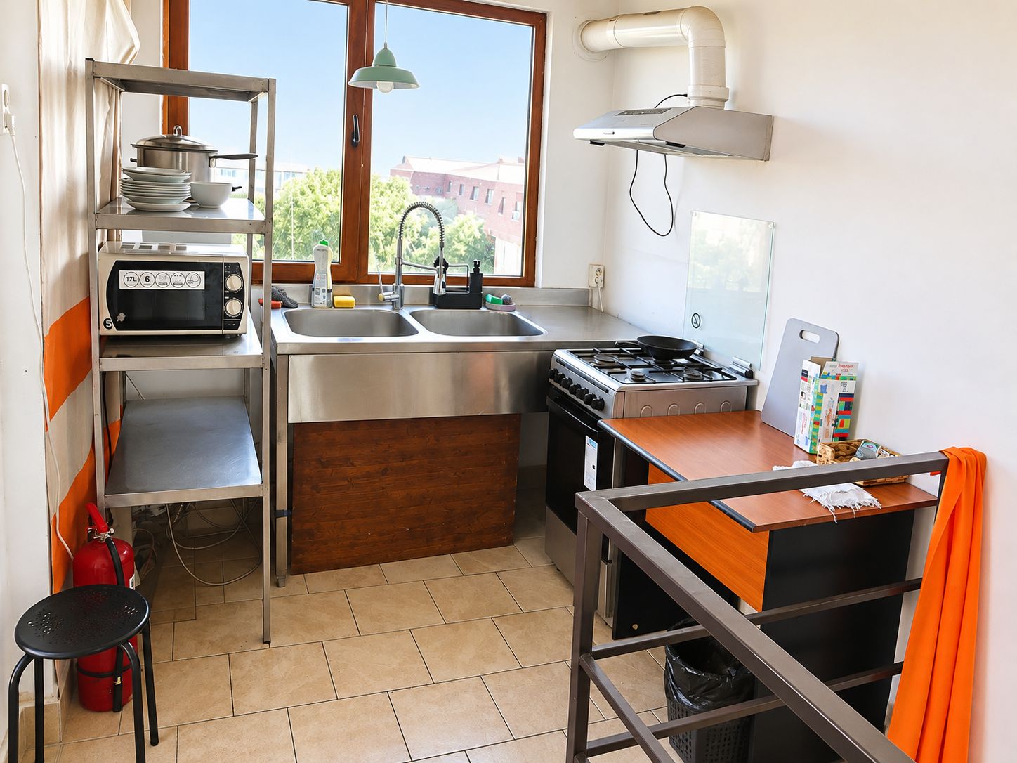Cocina compacta con microondas, fregadero, estufa y una pequeña zona de comedor.