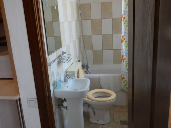 A bathroom with a sink, toilet, and bathtub.