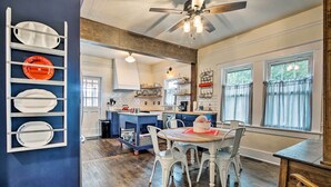 A spacious kitchen with a central island, white chairs, and a dining table. - Remodeled Historic Farmhouse ~ 20 Mi to KC! (Liberty)