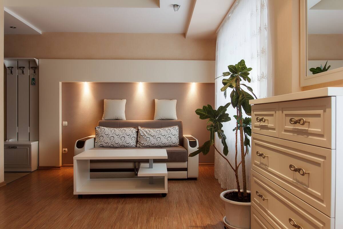 A modern living room with a sofa, a coffee table, and a dresser.
