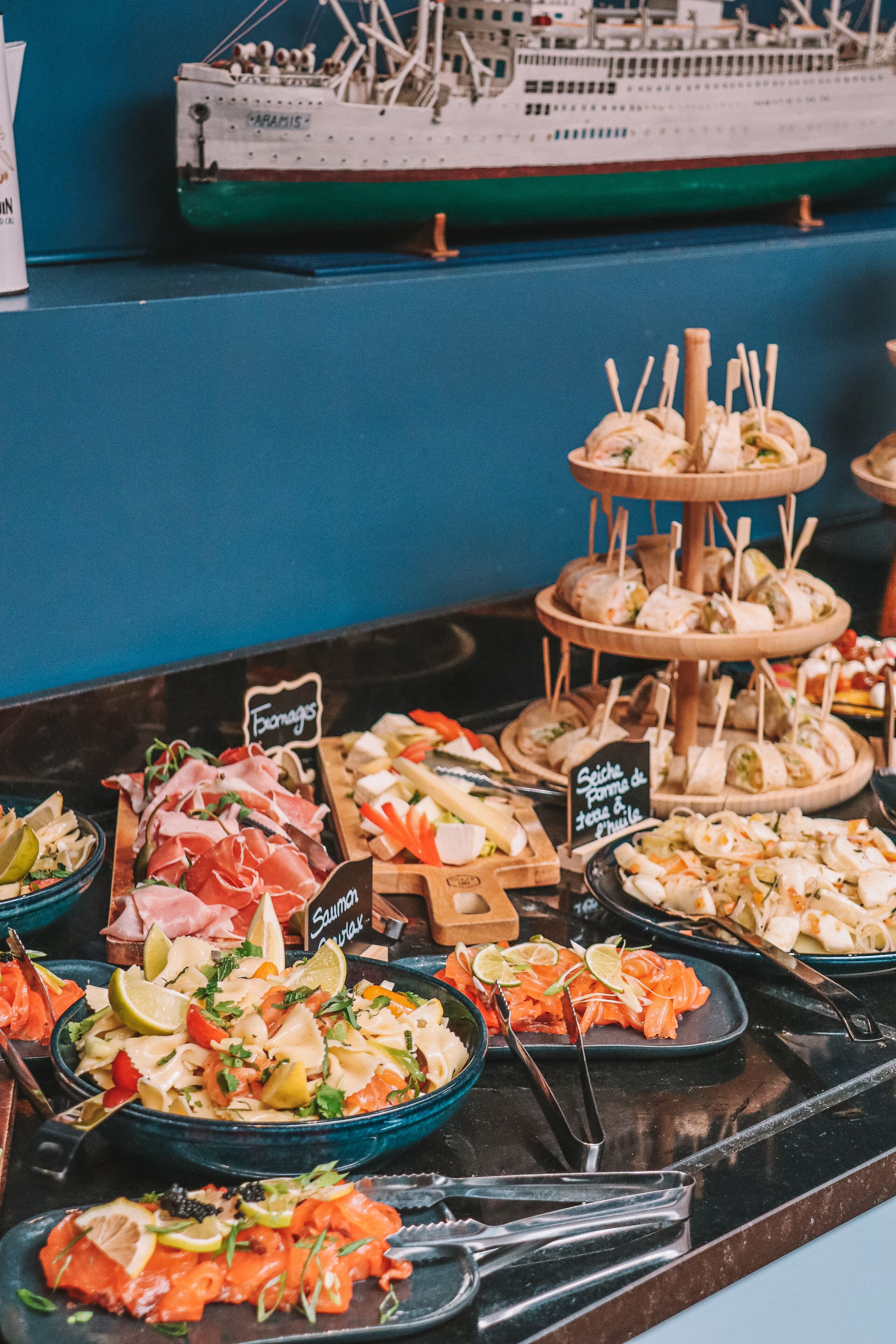 Un bufé con diversas opciones de comida, incluyendo ensaladas, carnes y mariscos.