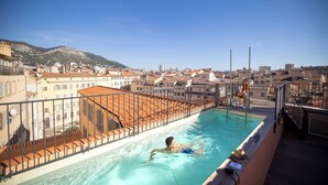 A rooftop swimming pool with a view of a cityscape and mountains in the background. - Hôtel L'Eautel Toulon Port (Toulon)