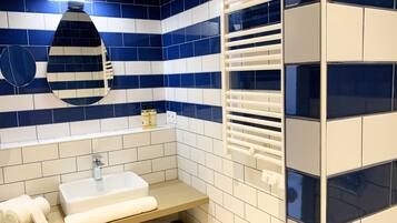 A bathroom with a white sink, a mirror, and a towel rack.