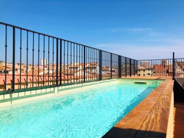 Una piscina al aire libre, sillones reclinables de piscina
